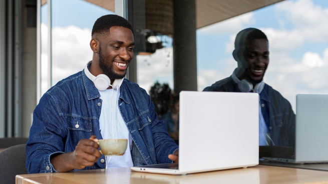 African freelancer working remotely on a laptop, exploring online freelancer-client acquisition methods.